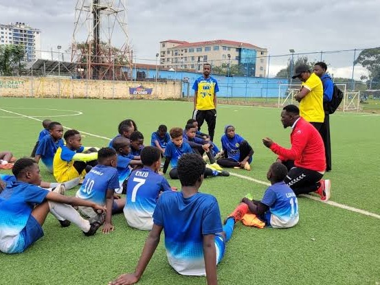 Coach briefing a youth team on the field