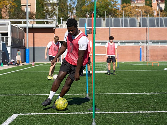 Players running fitness drills through cones